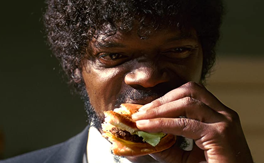 Imagen escena película pulp fiction Samuel Jackson comiendo big kahuna burger.